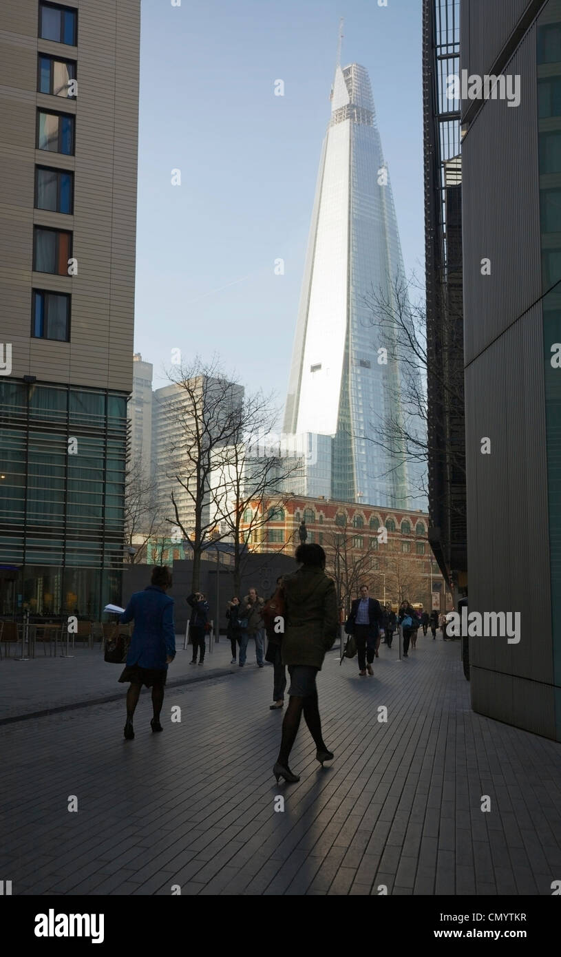 Menschen, die in einer bebauten Fußgängerzone in More London, Großbritannien, spazieren. Stockfoto