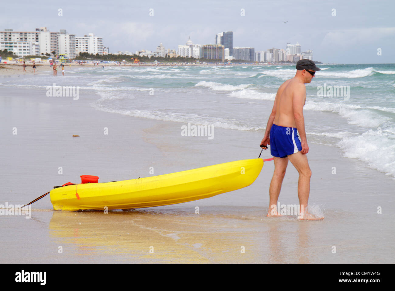 Miami Beach Florida, Atlantikküste, Surfen, Wellen, Wasser, Männer Männer Erwachsene Erwachsene, Badeanzug, gelbes Polyethylen-Kunststoff-Ozeankajak, Draggin Stockfoto