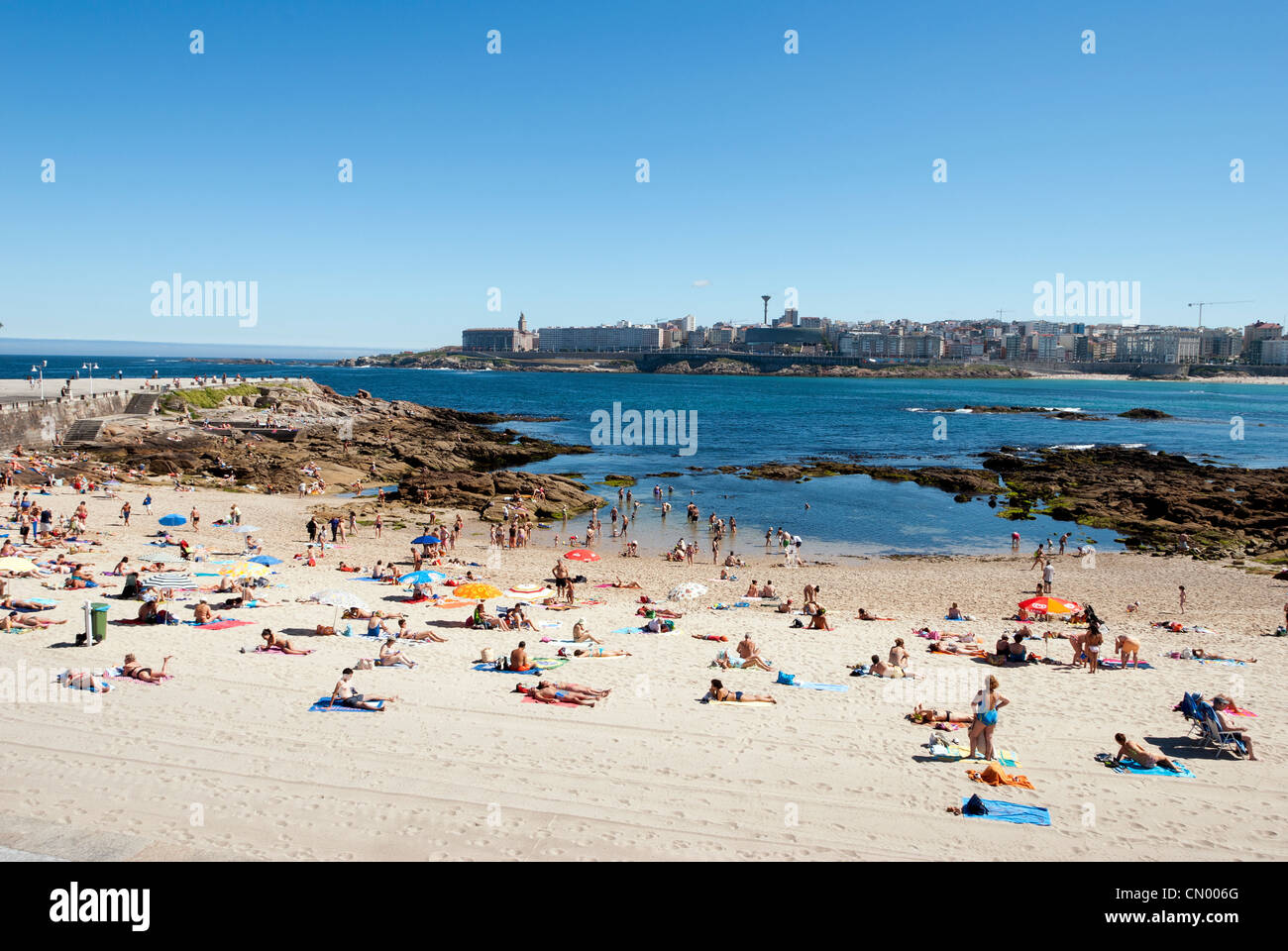 Menschen Sonnenbaden am Playa de Riazor Strand - Coruna, Galicien - Spanien Stockfoto