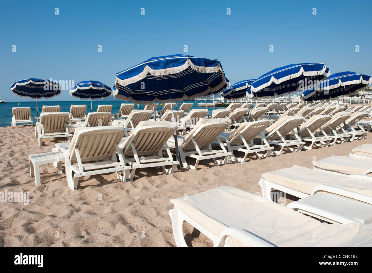 Unbesetzten liegen und Stühle am Strand entlang des Mittelmeers in Cannes, Frankreich. Stockfoto