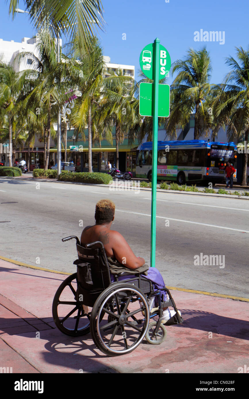 Miami Beach, Florida, Washington Avenue, schwarze Frau, weibliche Frauen, Rollstuhl, Bushaltestelle, warten, Behinderte spezielle Bedürfnisse, FL120114040 Stockfoto
