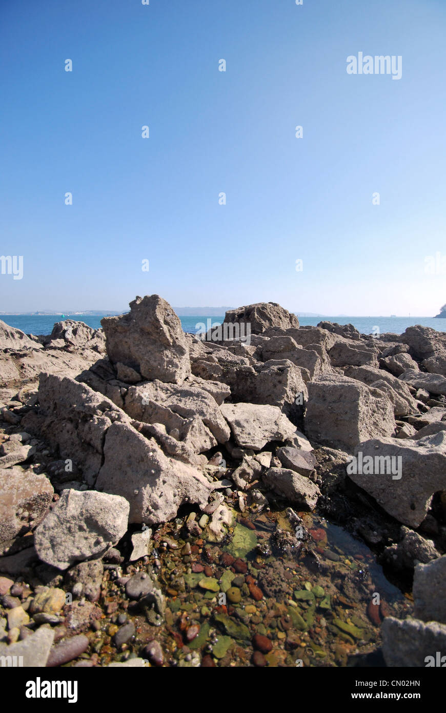 Ein Blick auf Plymouth Sound und Drakes Insel mit einem Felsenpool und Felsen im Vordergrund. Stockfoto