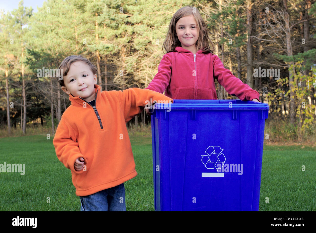 Jungen und Mädchen hält ein blauer Kasten Recyclingbehälter, Toronto, Ontario Stockfoto