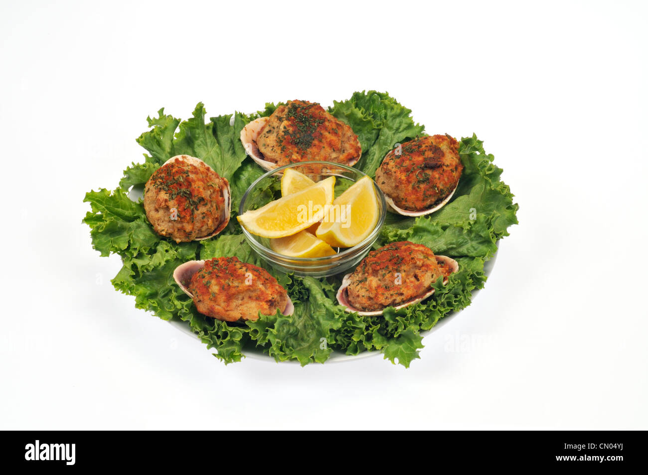 Teller mit gefüllten Muscheln auf Salatbett mit Zitronenspalten Stockfoto