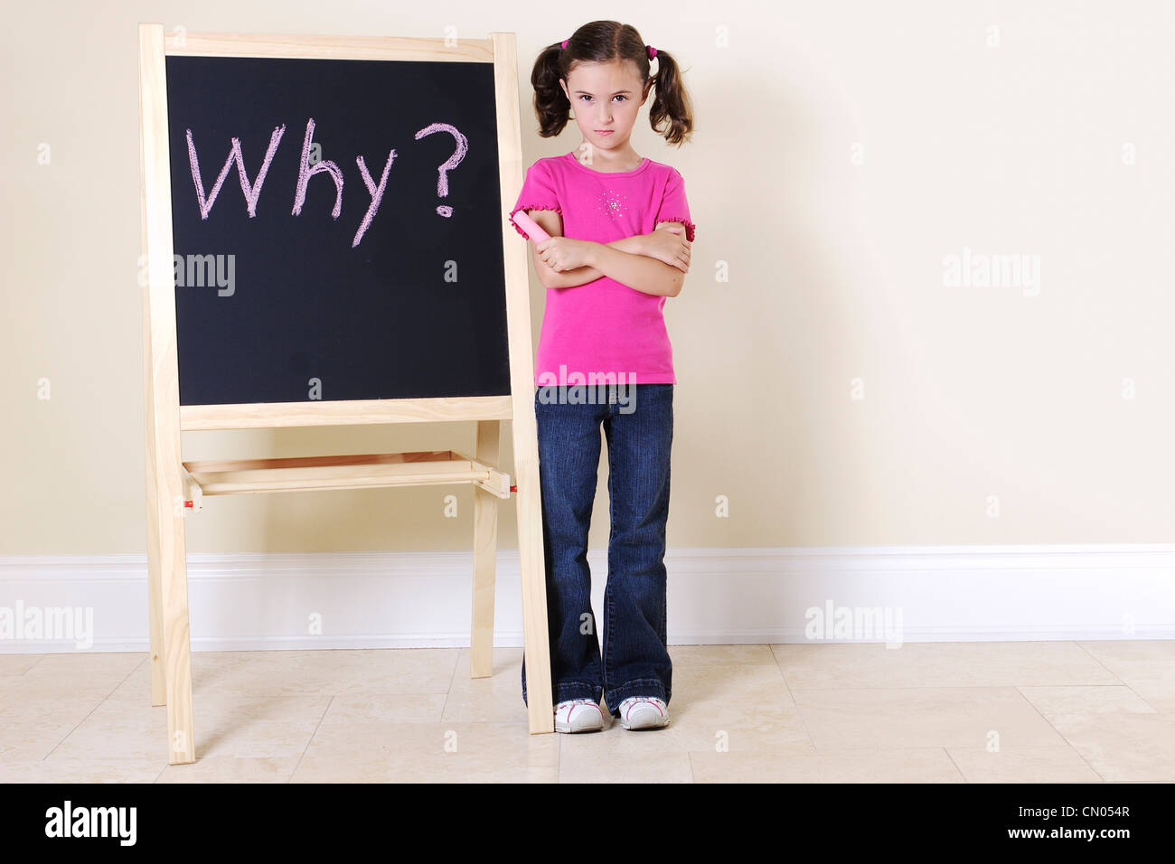 Young Girl schmollend neben Tafel geschrieben "Warum?" Stockfoto