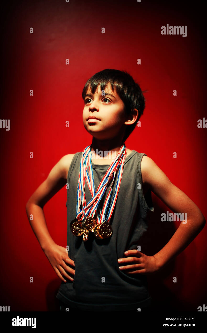 Gewinner. Junge Streiks Pose mit Kunststoff Goldmedaillen. Stockfoto