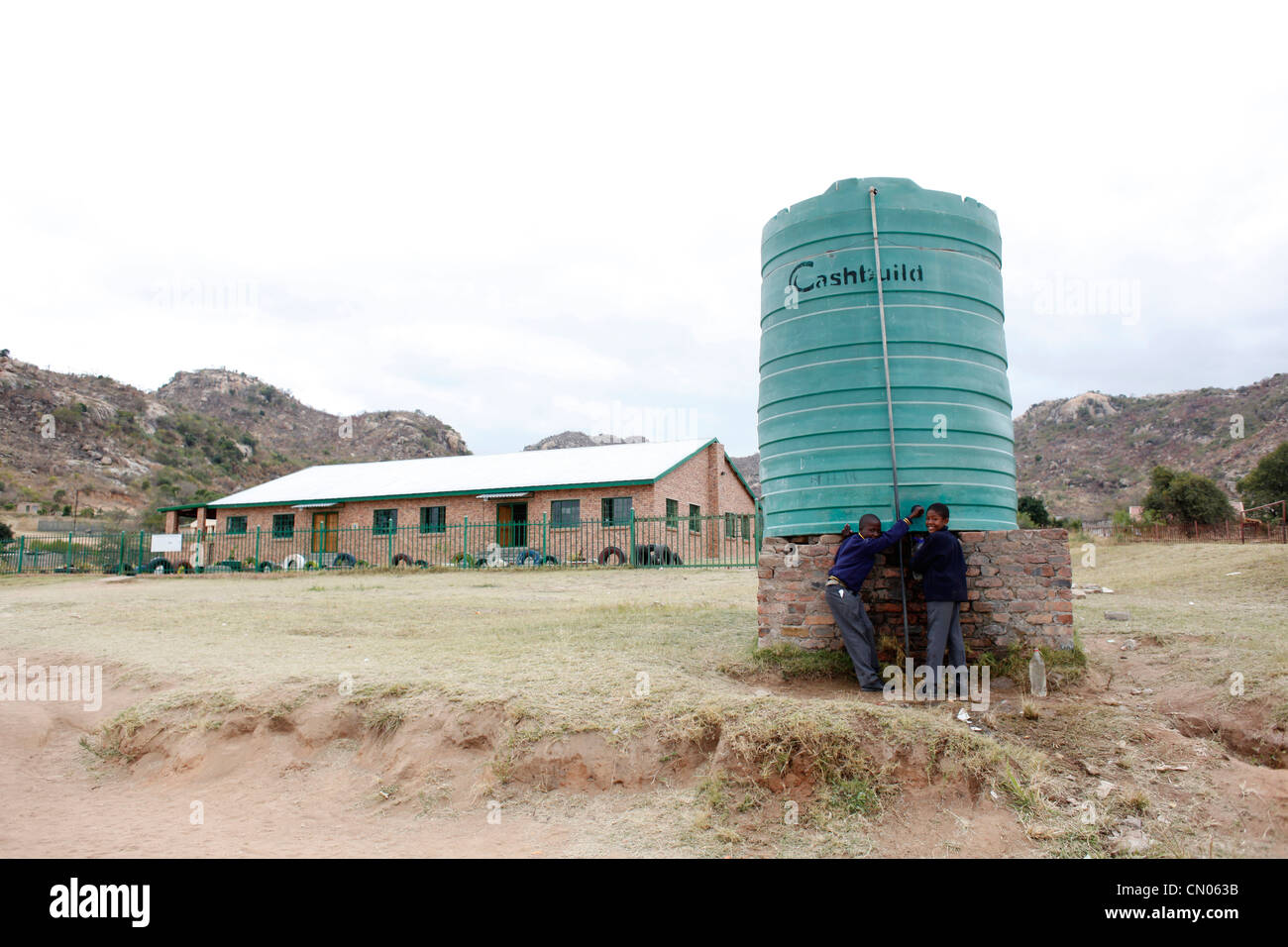 Studenten sammeln Wasser aus einem Tank installiert auf ihrem Schulhof. Hlau Hlau, Mpumalanga, Südafrika Stockfoto
