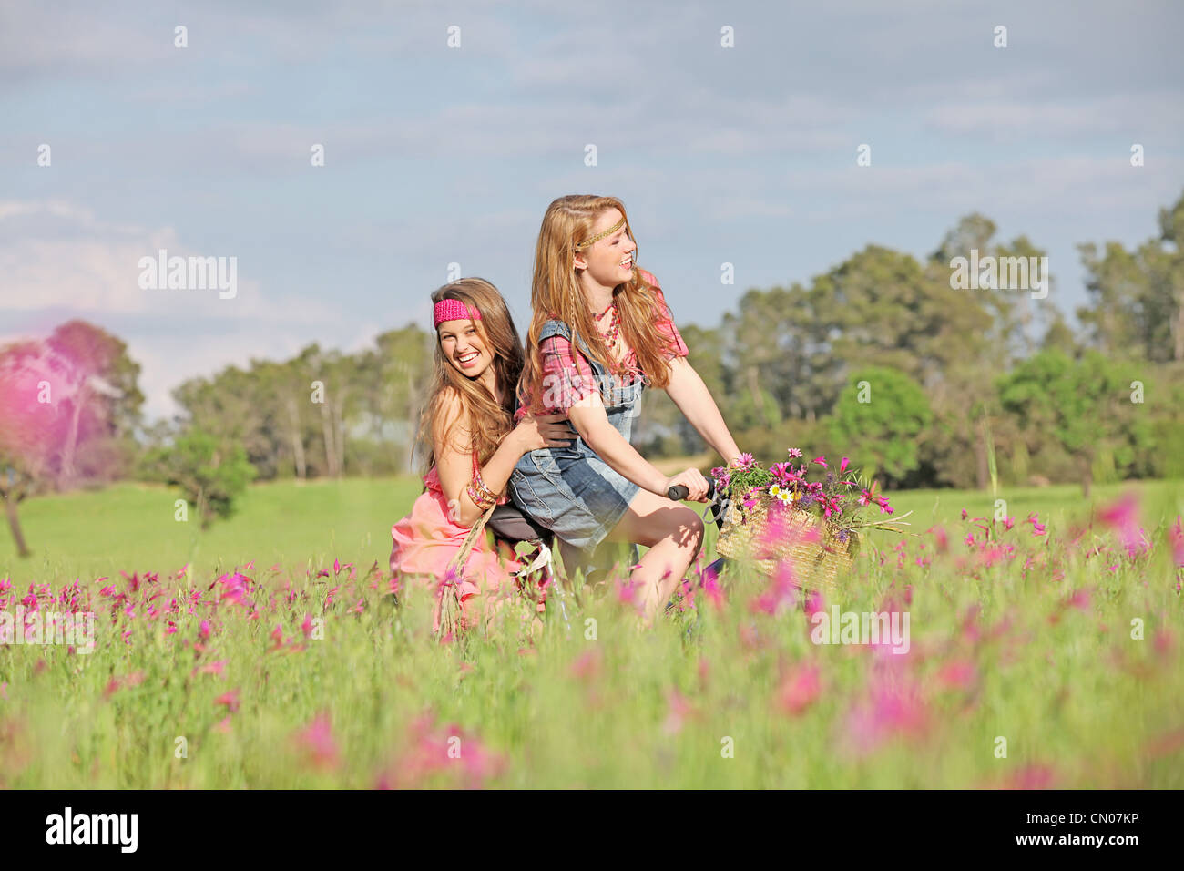 glückliche Mädchen Reiten Fahrrad oder mit dem Fahrrad im Sommerwiese Stockfoto