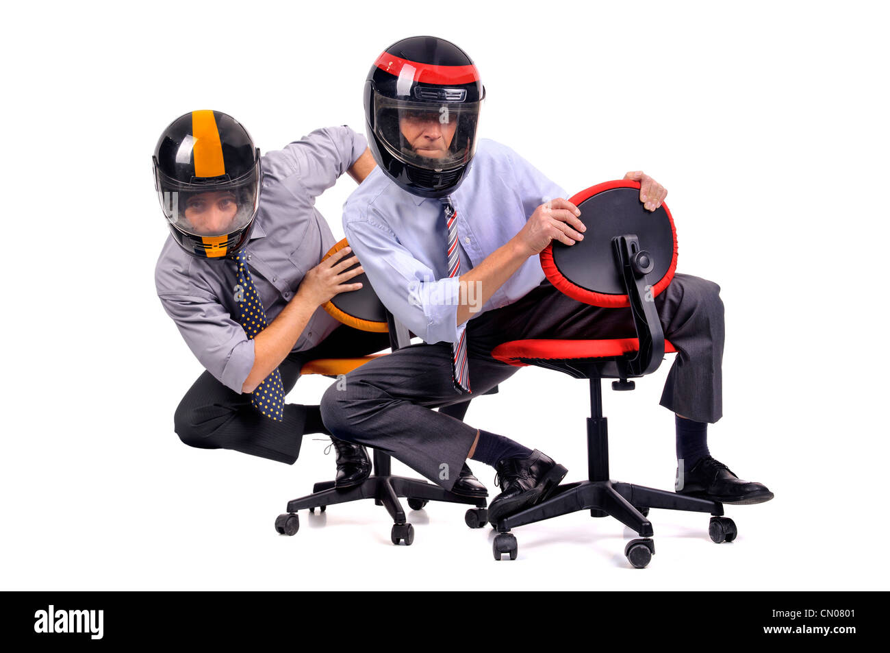 Geschäftsleute in Stühlen mit Helmen racing Stockfoto