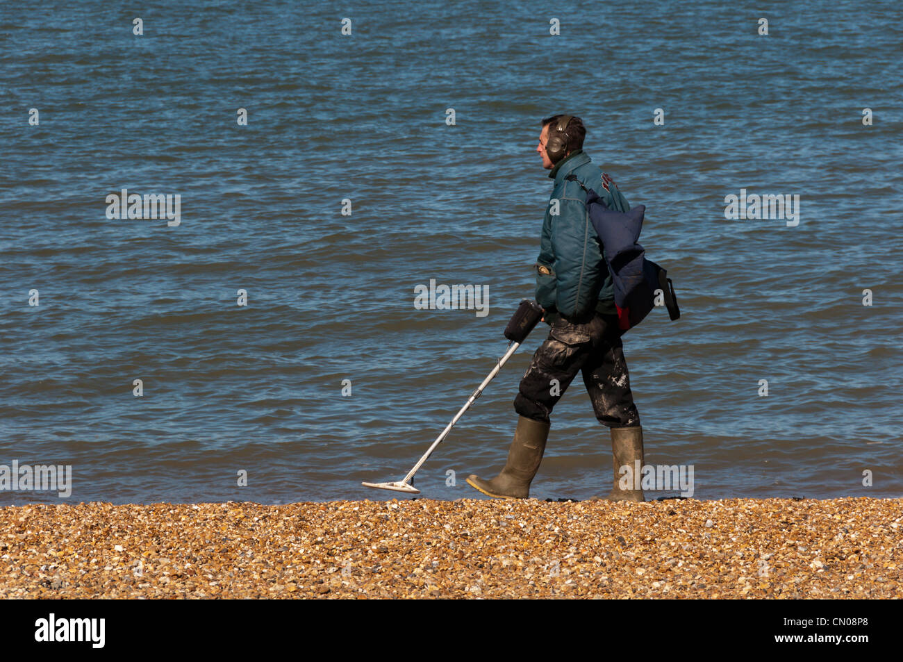 Ein Mann mit einem Metall-Detektor an der Küste. Stockfoto