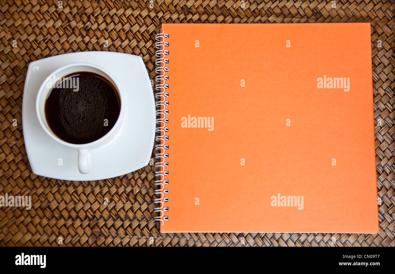 Orange Notebook und Kaffee Stockfoto