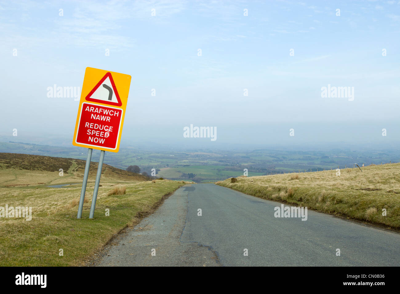 Arafwch Nawr, verringern Geschwindigkeit jetzt Straßenschild eine walisische Landschaft unterwegs. Stockfoto