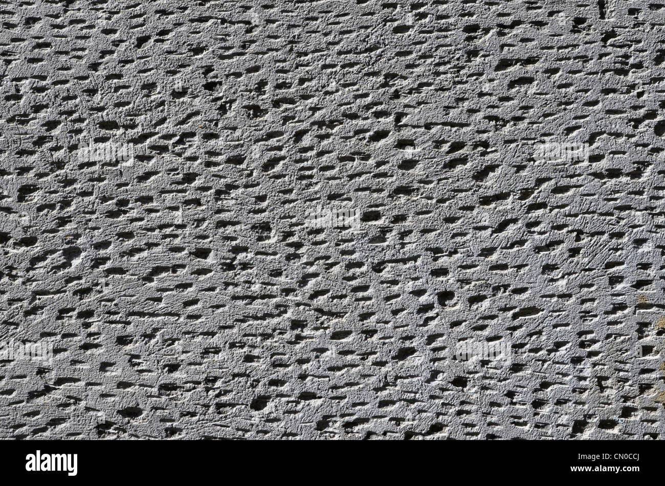 Detail der Außenverputzte Wandoberfläche mit Schlüsselmarken. Holprige Oberflächenstruktur, unregelmäßiges Muster, nicht einheitlich. Stockfoto
