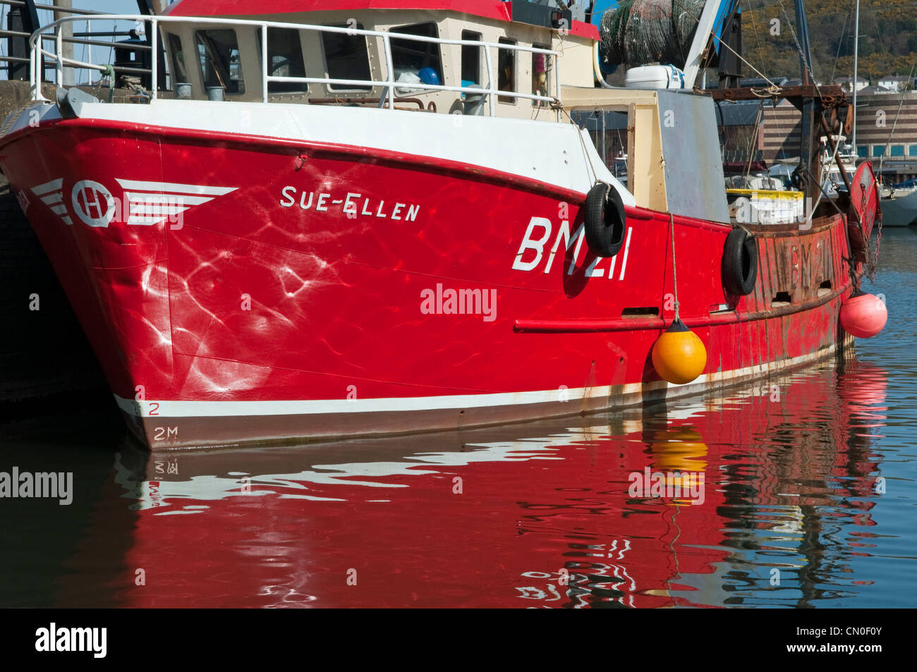 Sue Ellen, eine rote Fischerboot vor Anker im Boot Fischerviertel von Swansea Marina in Süd-Wales mit Reflexionen Stockfoto