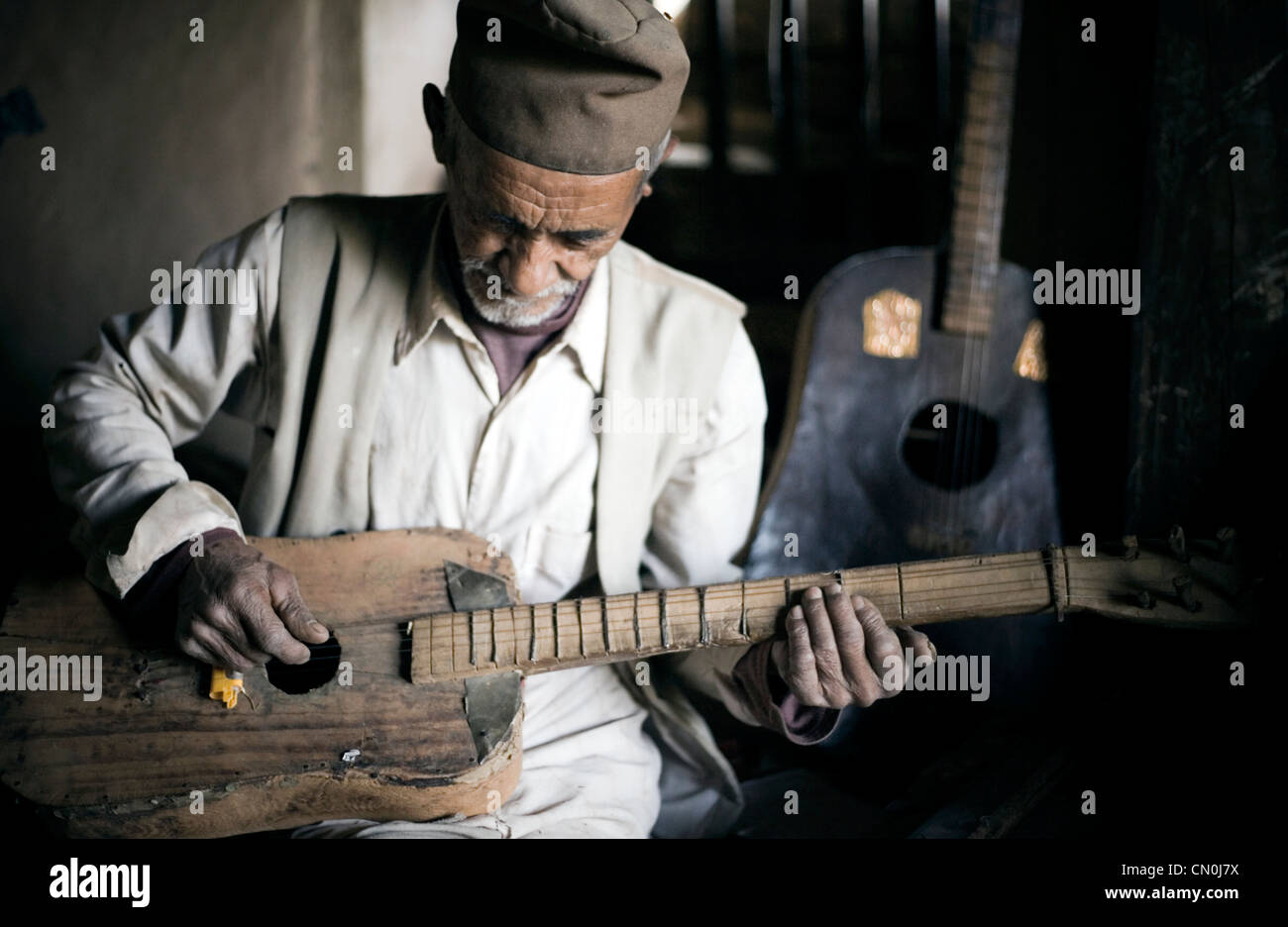 Nepal, die lokaler Mann auf seiner Hand gemacht-Gitarre spielt, wurde in seiner Werkstatt Foto aufgenommen. Stockfoto