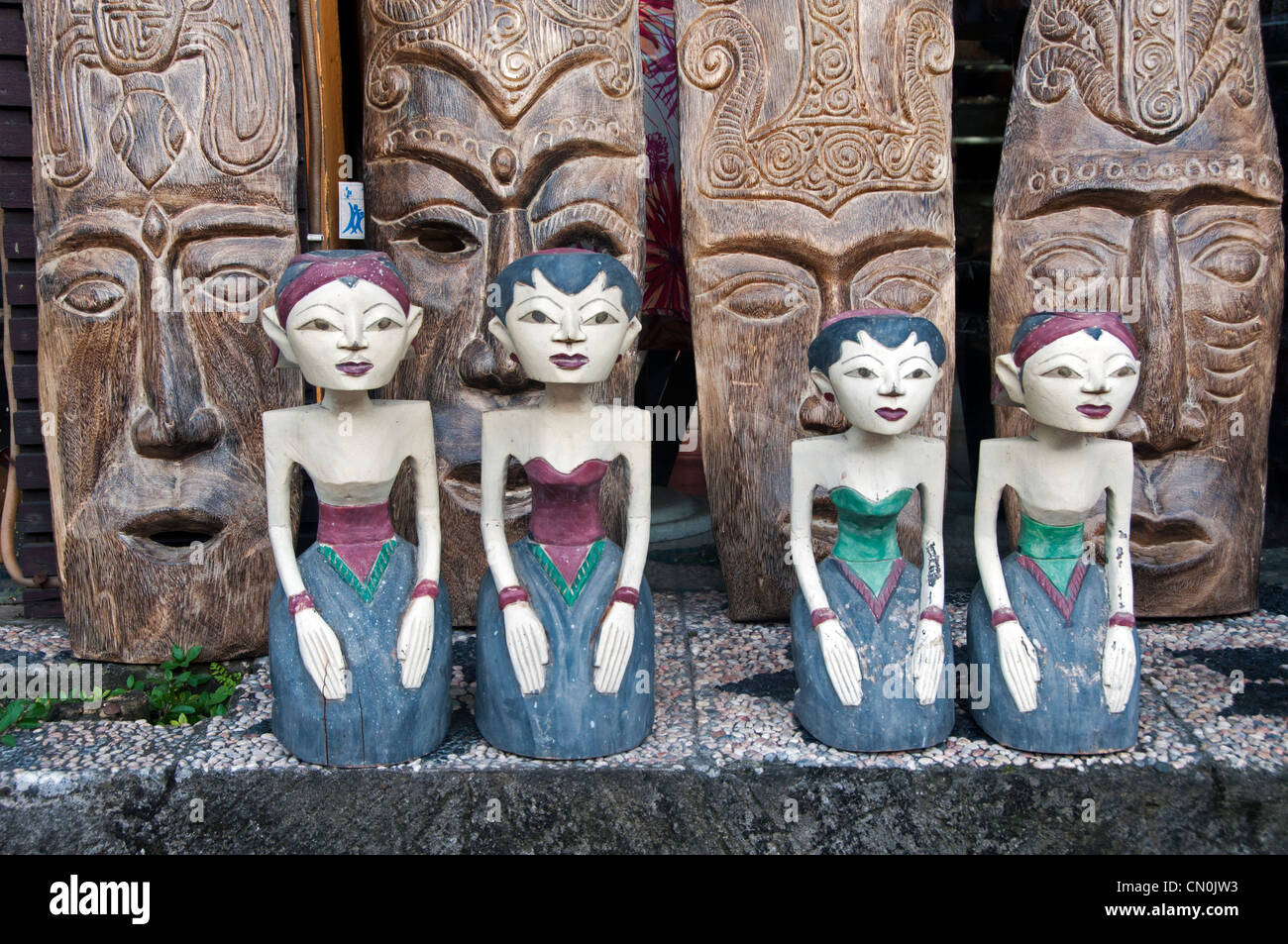 Holzkunst aus Mädchen und Holzmaske aus Bali auf dem Hintergrund Stockfoto