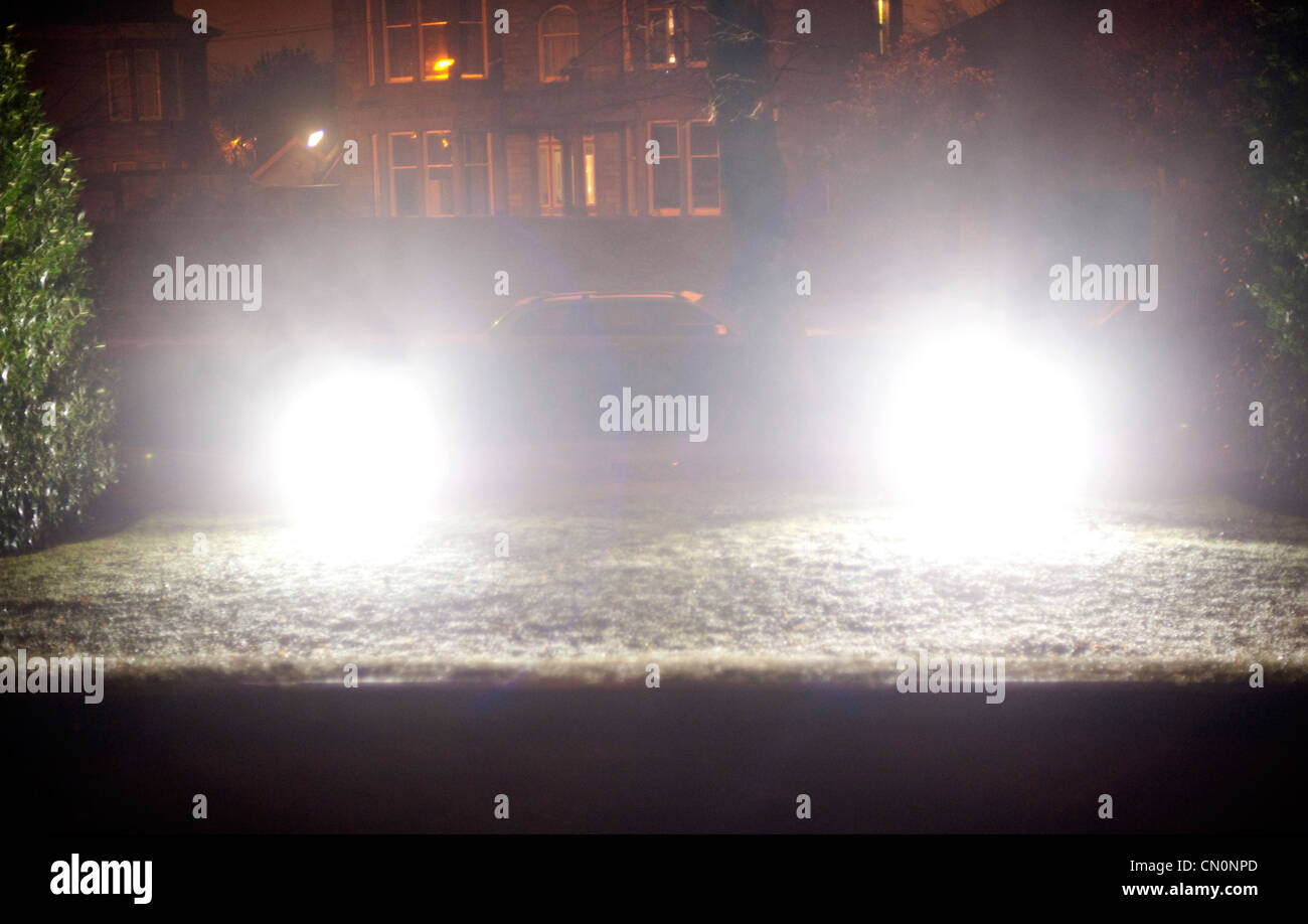 Scheinwerfer leuchten auf dem Rasen vor einem Gebäude an einem kalten Winterabend Stockfoto