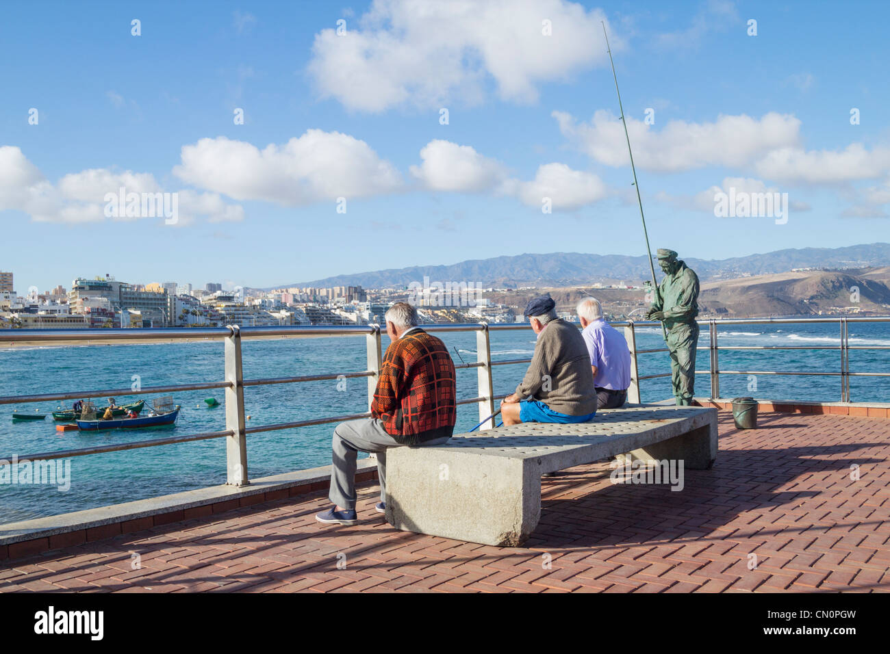 Drei ältere spanische Männer sitzen auf der Bank am La Puntilla am östlichen Ende von Las Canteras Strand in Las Palmas, Gran Canaria Stockfoto