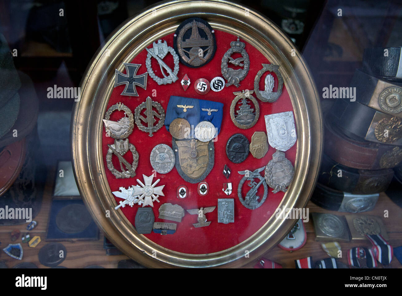Nazi und SS-Insignien, Abzeichen und Medaillen auf rotem Grund für den Verkauf in einem Antiquitätenladen in Triest Italien angezeigt Stockfoto