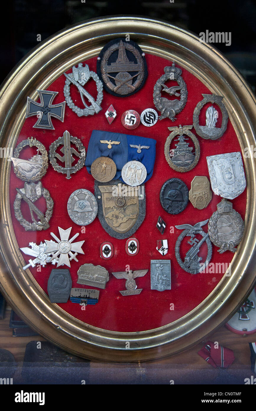 Nazi und SS-Insignien, Abzeichen und Medaillen auf rotem Grund für den Verkauf in einem Antiquitätenladen in Triest Italien angezeigt Stockfoto