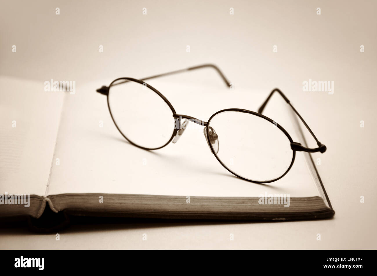 Buch und Brille als Symbol für das Konzept der Gewohnheit zu lesen oder zu studieren Stockfoto