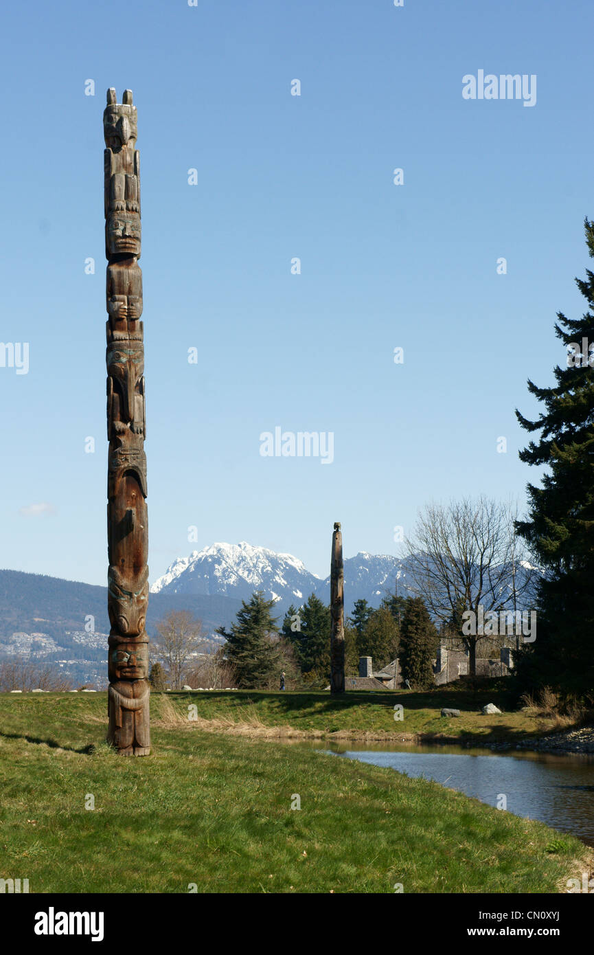 West Coast First Nations Totempfähle mit Bergen im Hintergrund, Museum für Anthropologie, Universität von British Columbia, Vancouver, Kanada. Stockfoto