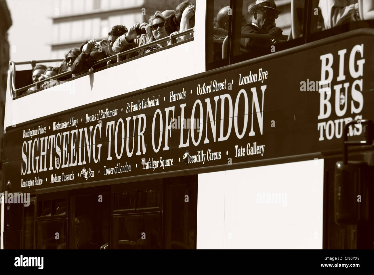 Nachschlagen von Touristen auf der Oberseite einen oben offenen Touristenbus in London Stockfoto