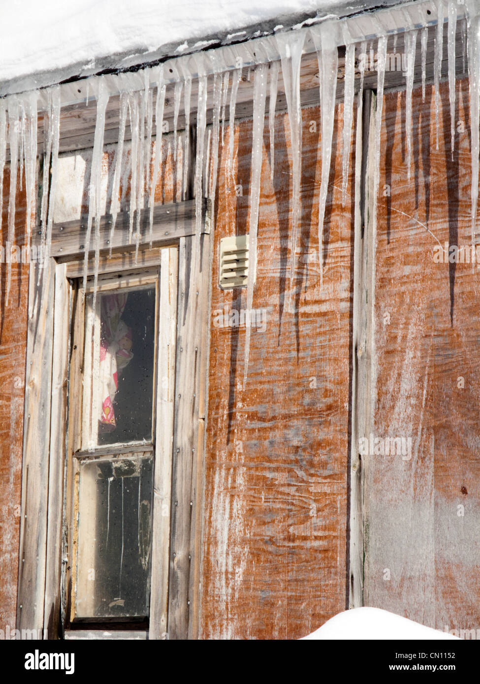 Eiszapfen herunterhängen vom Dach eines Hauses Stockfoto