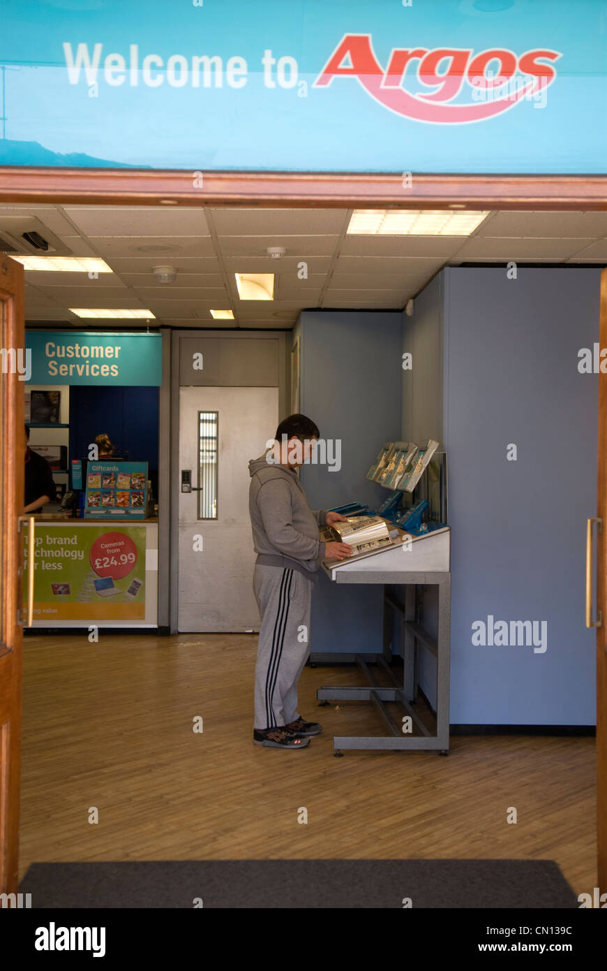 Kunden surfen Argos Katalog im Shop, Farnham, Surrey, UK. Stockfoto
