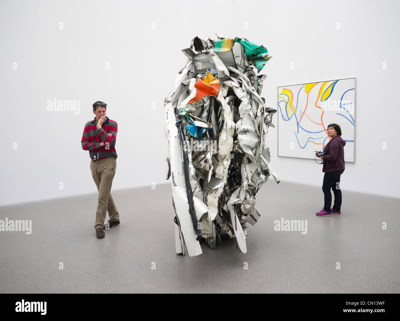 Besucher betrachten Acme Thunderer von John Chamberlain Bildhauerei an der Pinakothek der Moderne-Kunst-Museum in München Stockfoto