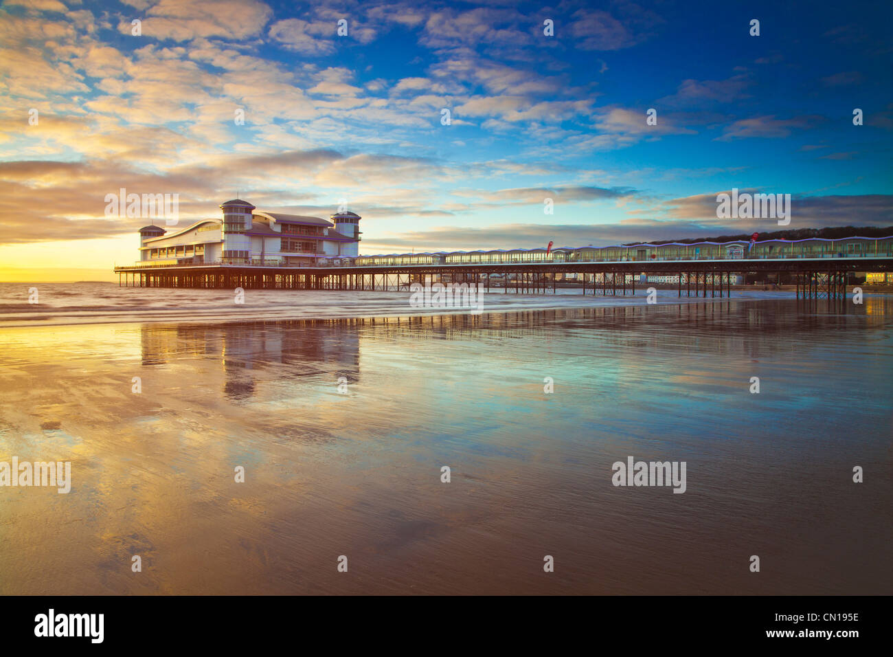 Goldene Abendlicht fällt auf der Grand Pier am Weston-Super-Mare, Somerset, England, Vereinigtes Königreich spiegelt sich im nassen Sand an den hohen Gezeiten. Stockfoto