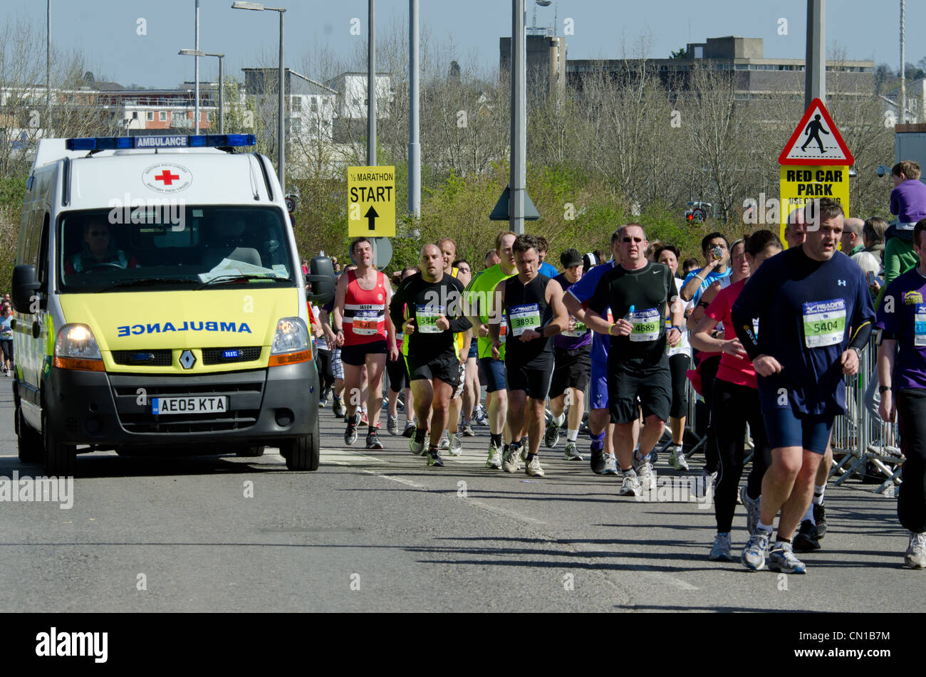 Ein Krankenwagen vorbeifahren Läufer in der Lesung eine halbe Marathon 2012 Stockfoto