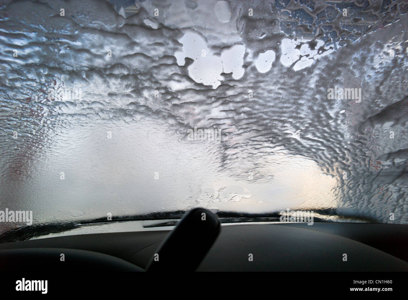 Blick durch die Windschutzscheibe eines Autos in einer automatischen Waschanlage. Stockfoto