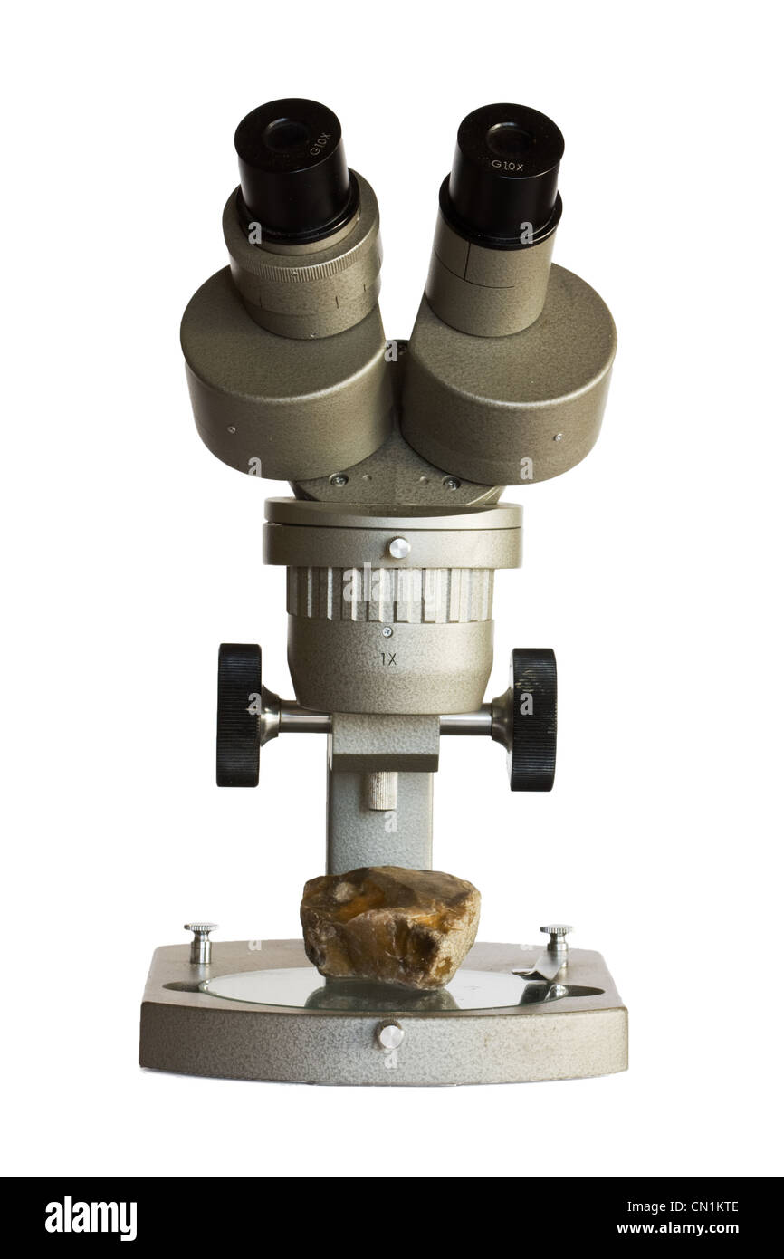 Dem Mikroskop untersuchen, ein Stein, isoliert auf weiss. Stockfoto