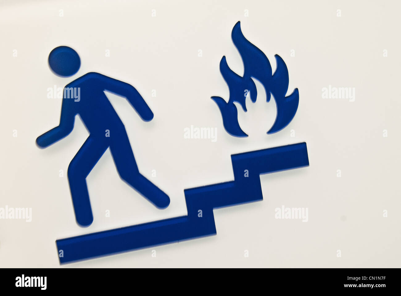 Ein blaues "benutzen Sie die Treppe im Brandfall" Schild vor weißem Hintergrund Stockfoto