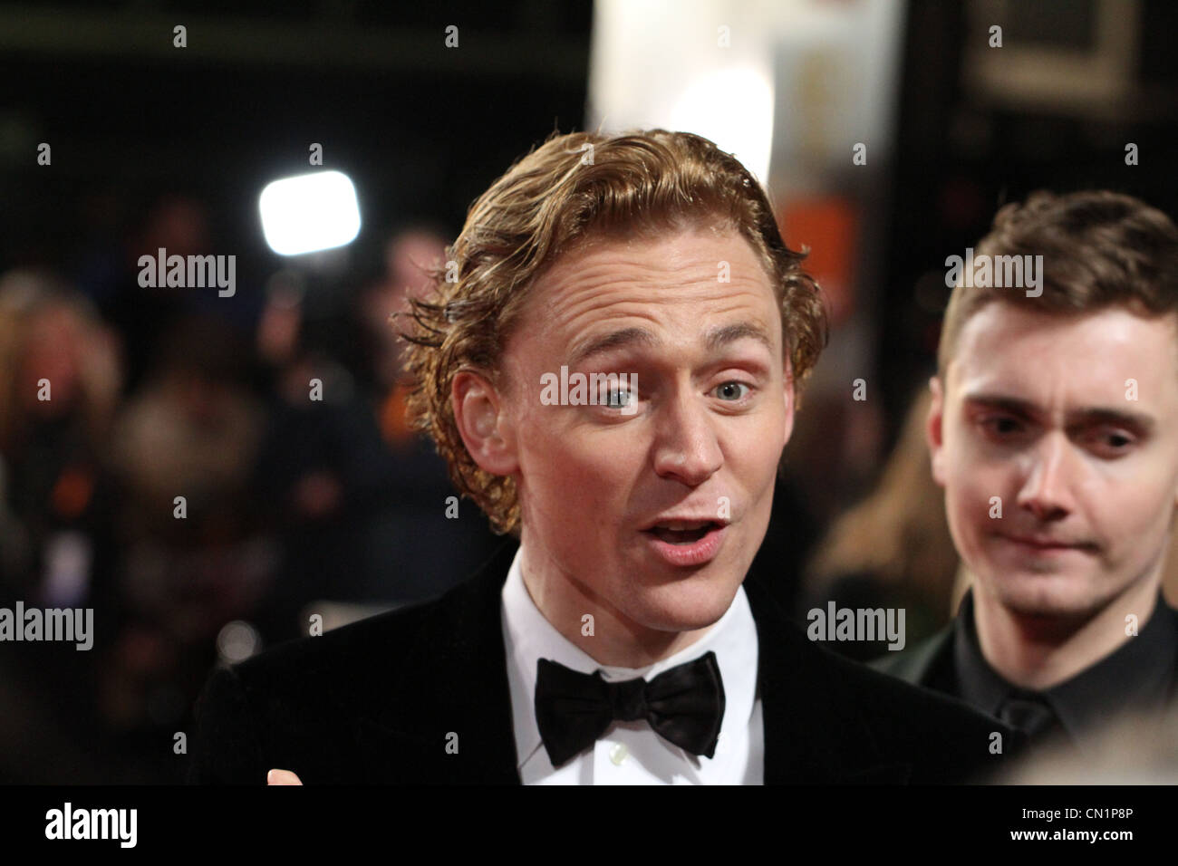 Schauspieler Tom Hiddleston begrüßt das Publikum bei den BAFTA Film Awards 2012 in Covent Garden in London Stockfoto