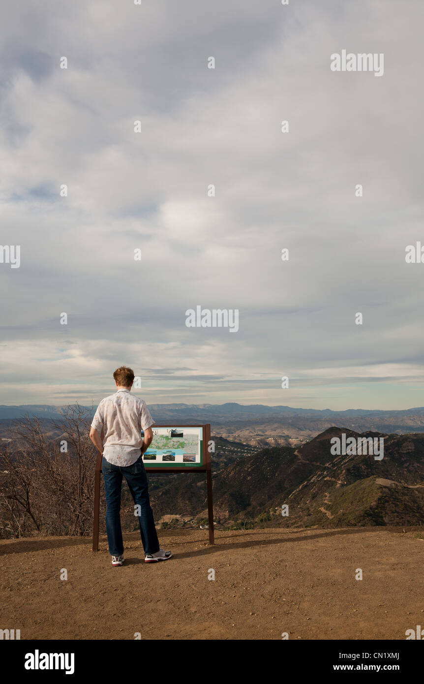 Mann liest Informationen Zeichen, Kalifornien, USA Stockfoto
