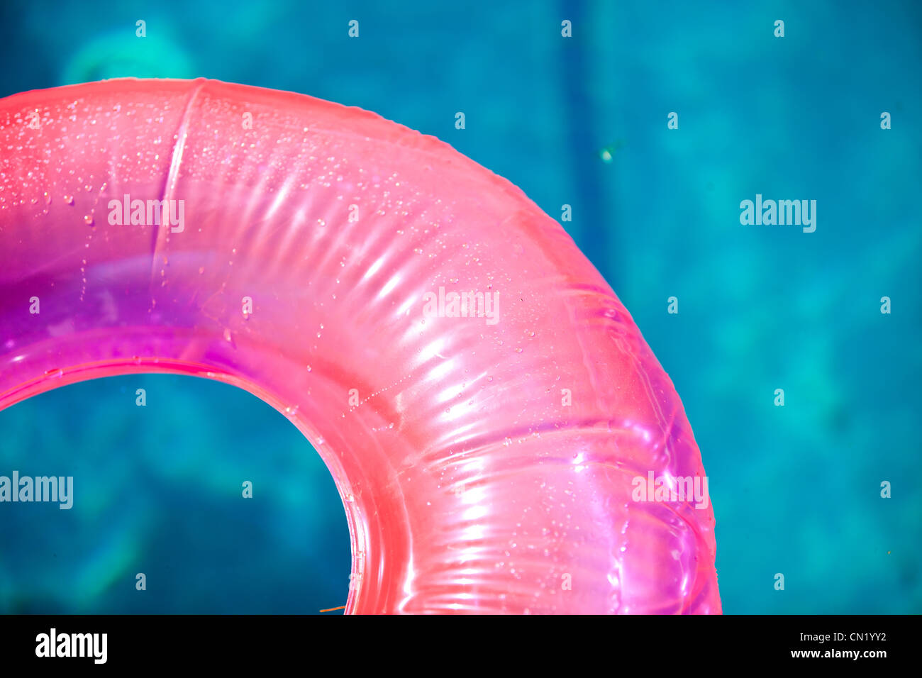 Schwimmendes aufblasbares Spielzeug auf dem Pool im Sommer beleuchtet von der warmen Sonne Stockfoto