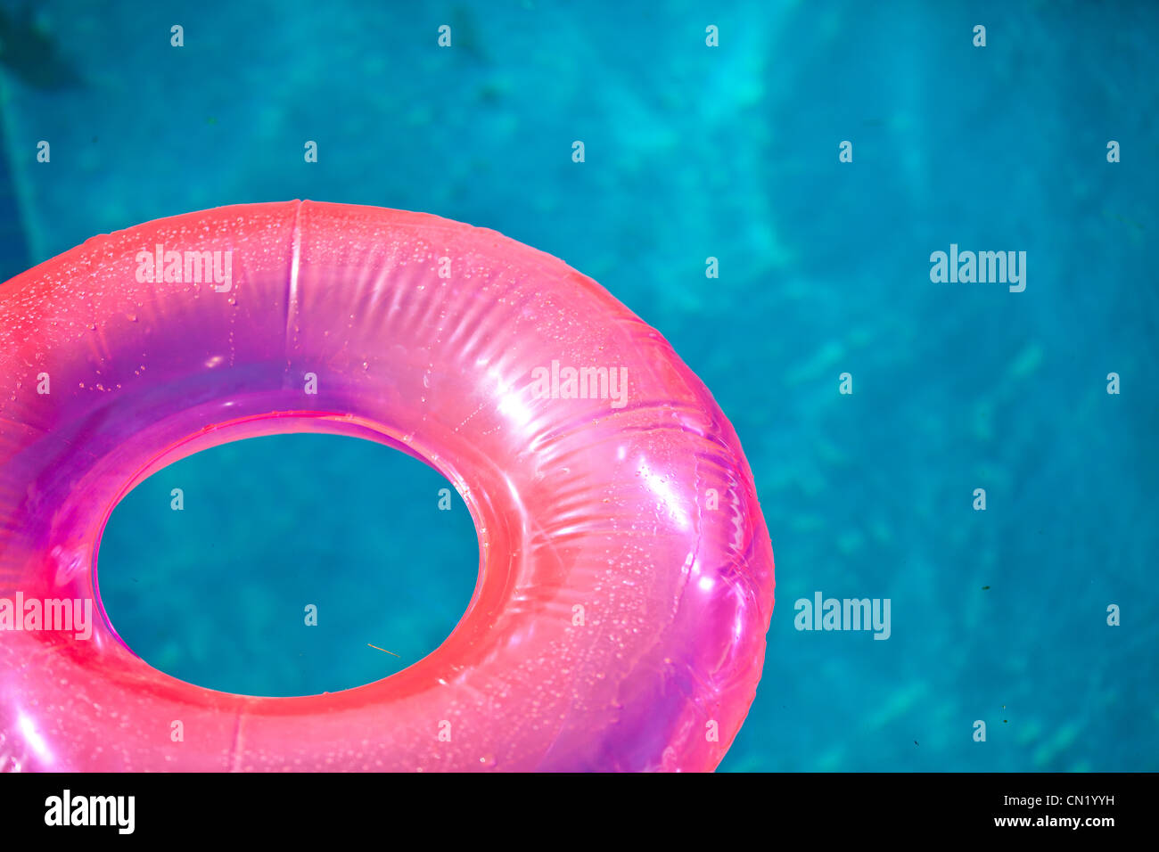 Schwimmendes aufblasbares Spielzeug auf dem Pool im Sommer beleuchtet von der warmen Sonne Stockfoto