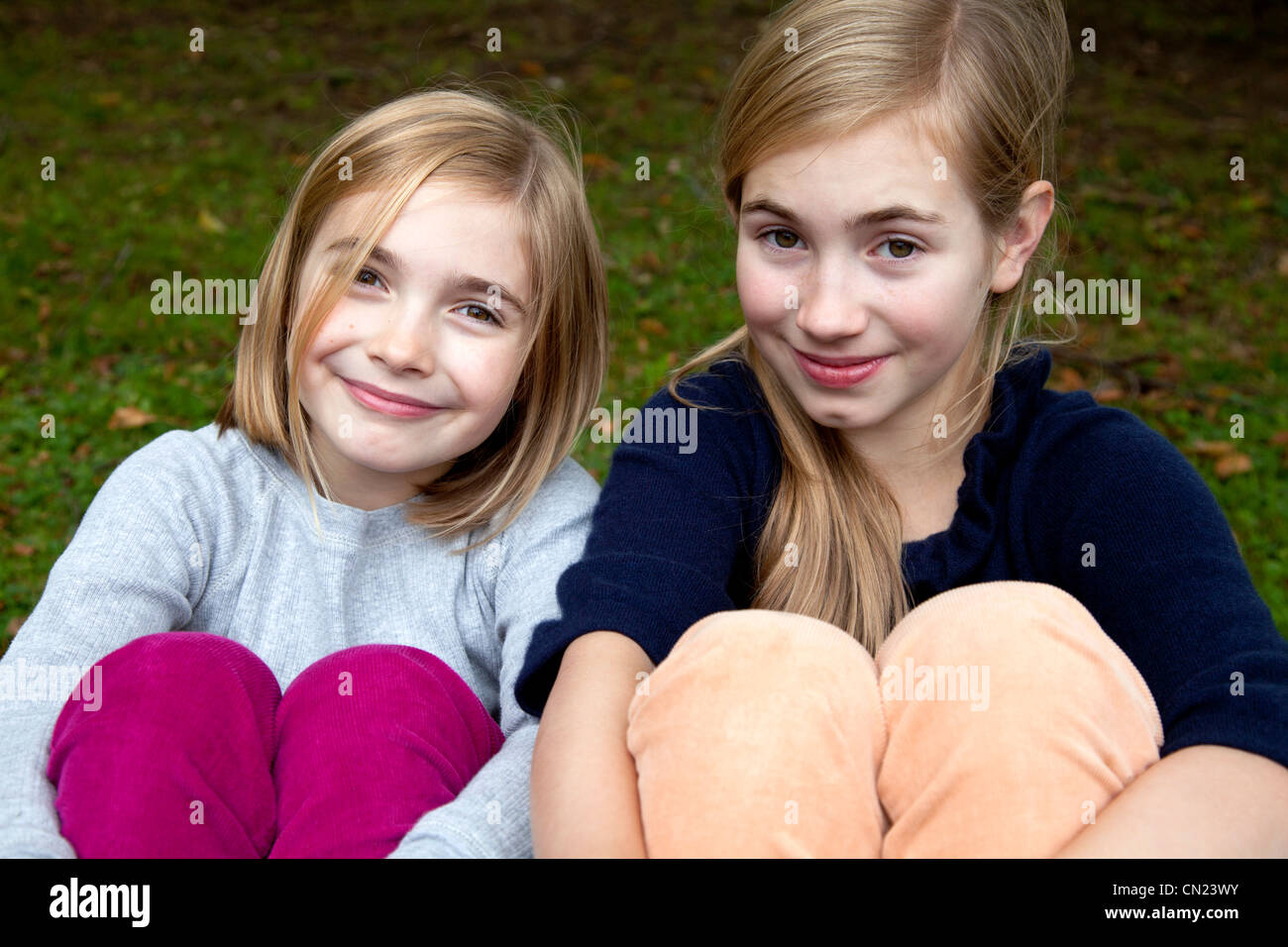 Zwei lächelnde Mädchen mit Armen Beine umwickelt Stockfoto