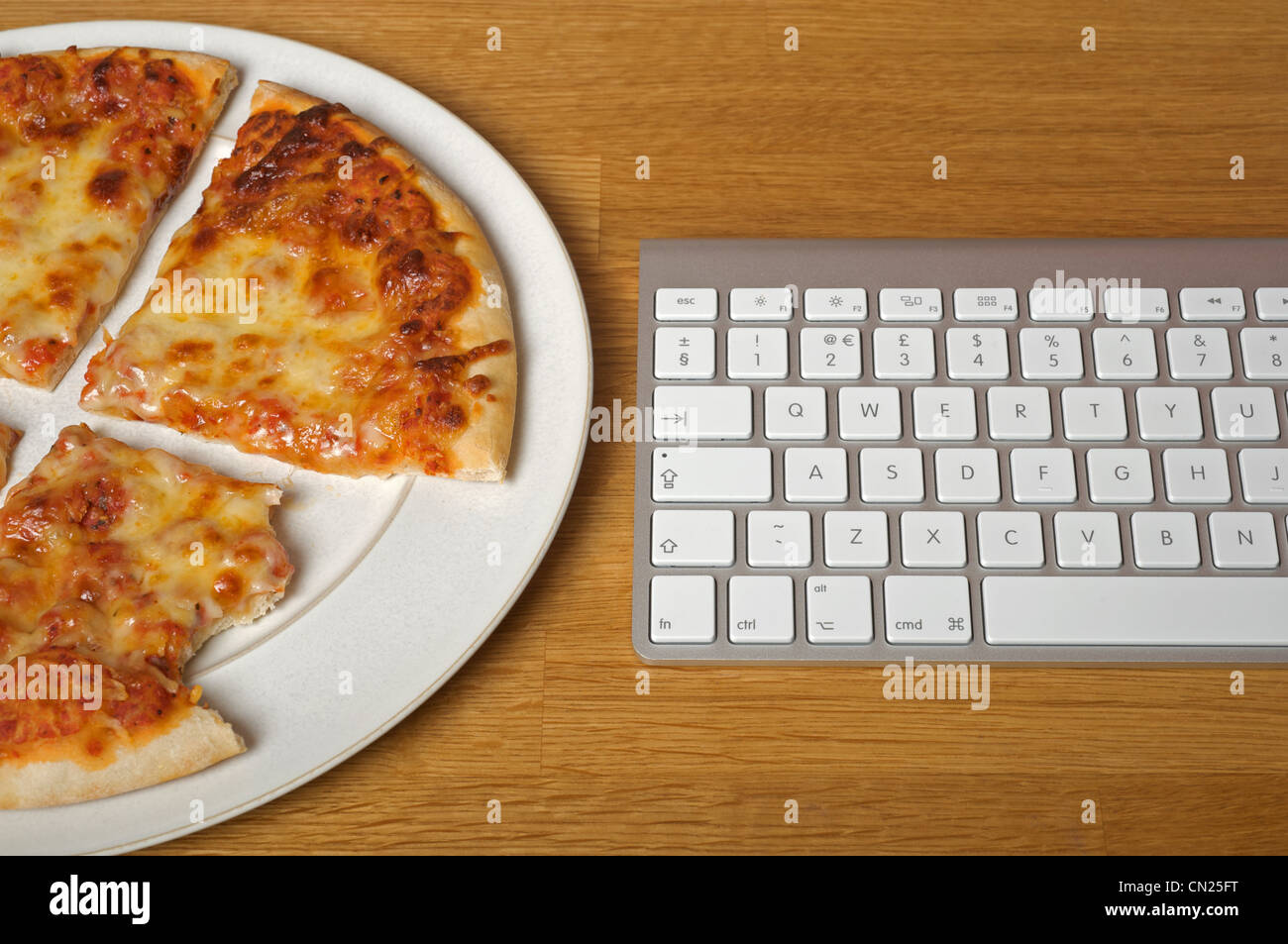 Hausgemachte Pizza neben Computer-Tastatur Stockfoto