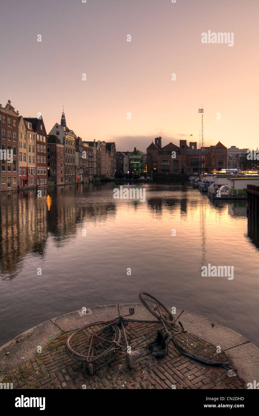 Rostigen Fahrrad liegt am Kanal, Dämmerungen, Amsterdam, Holland Stockfoto