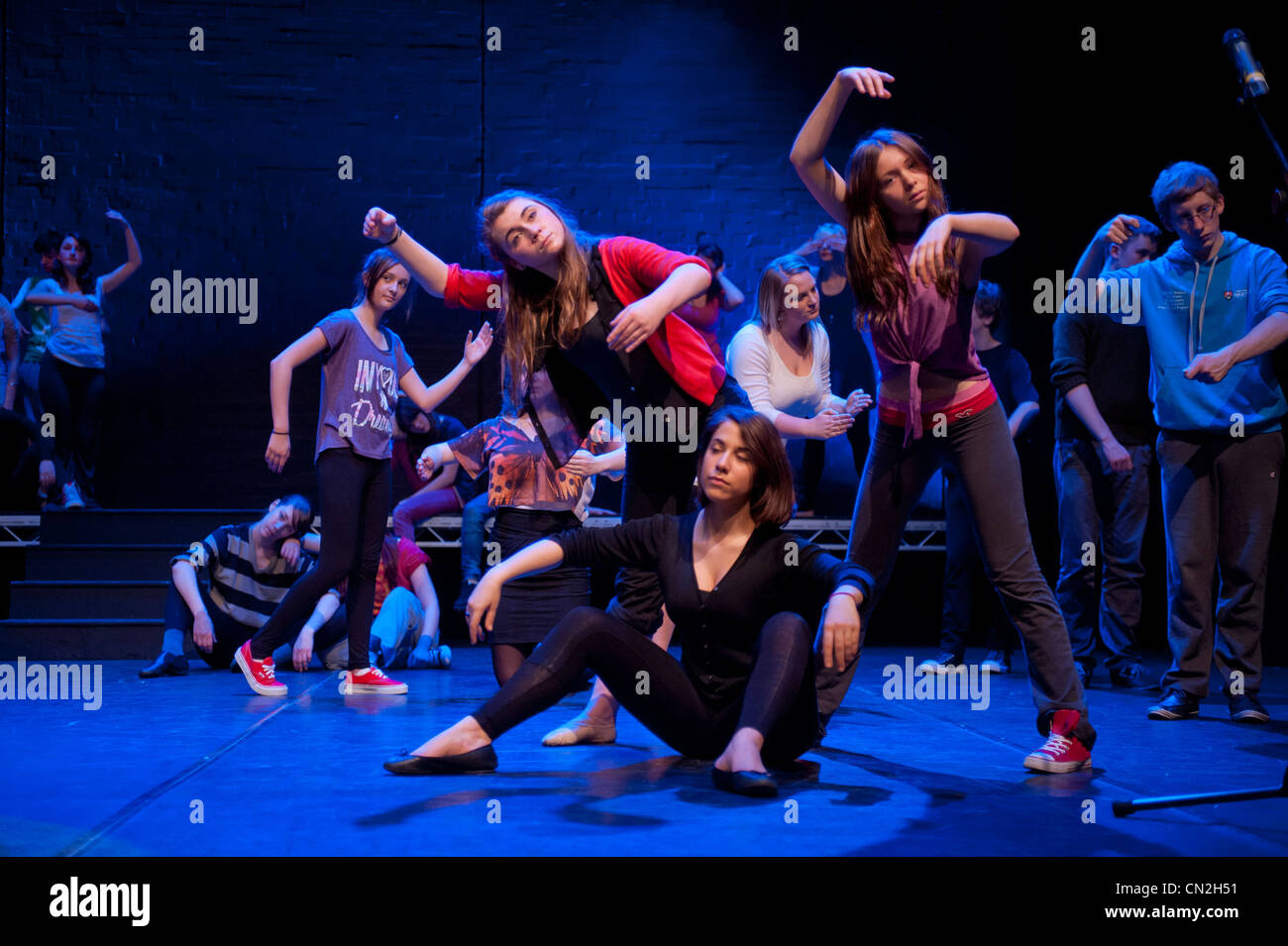 Eine Gruppe von jungen und Mädchen, Teenager singen und tanzen in einem Amateur Musiktheater-Leistung-Produktion in einem Theater. UK Stockfoto