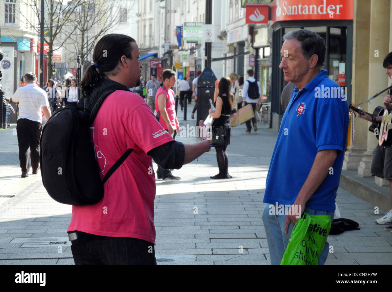 Mann gesprochen wird von einem Charity-Arbeiter in einem Cheltenham Straße Stockfoto