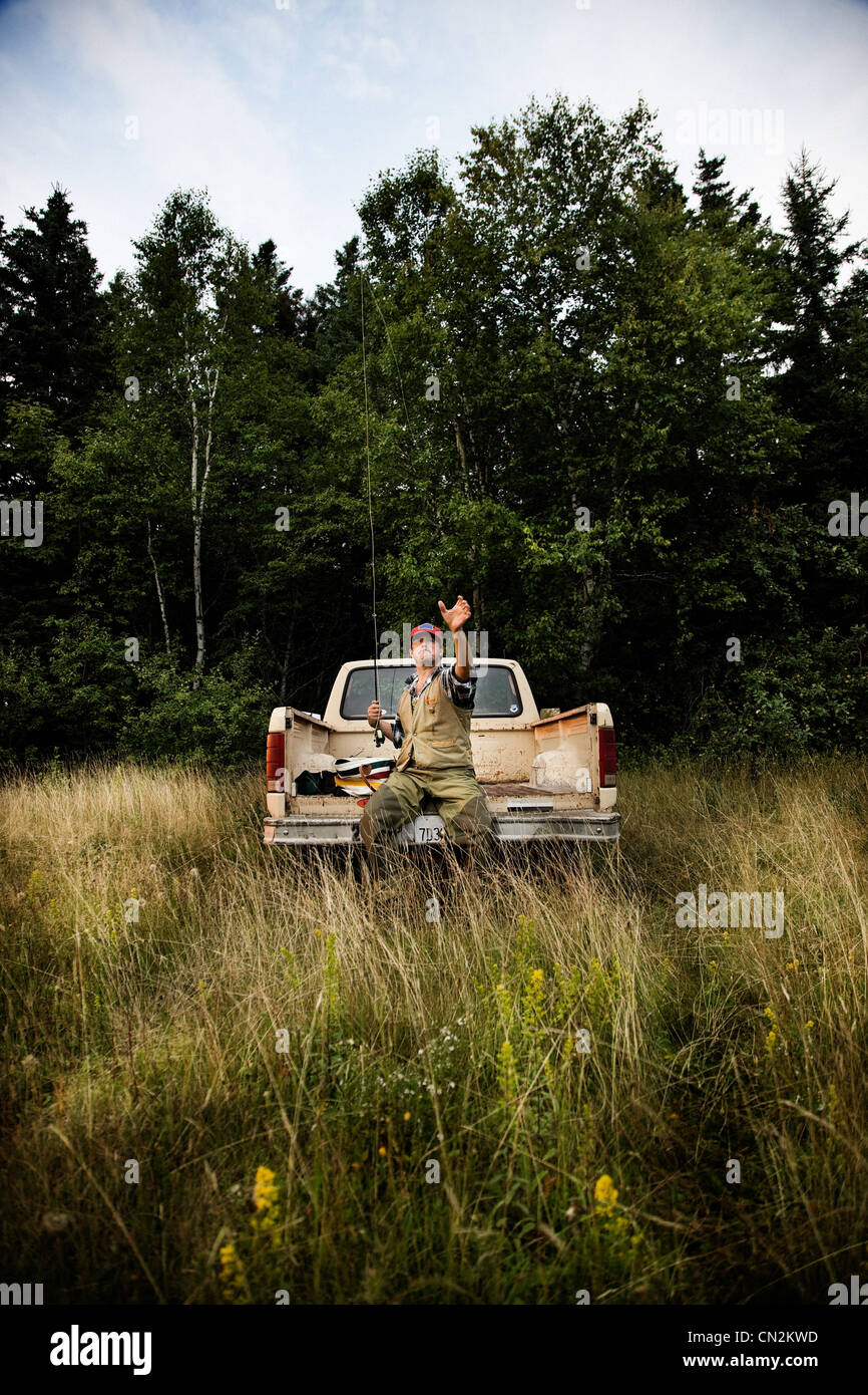 Fischer mit Stab auf Rückseite des Pickup-Truck, Cape Breton Island, Nova Scotia Stockfoto