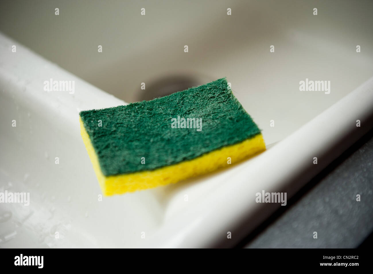 Reinigungsschwamm am Rand der Spüle, Nahaufnahme Stockfoto