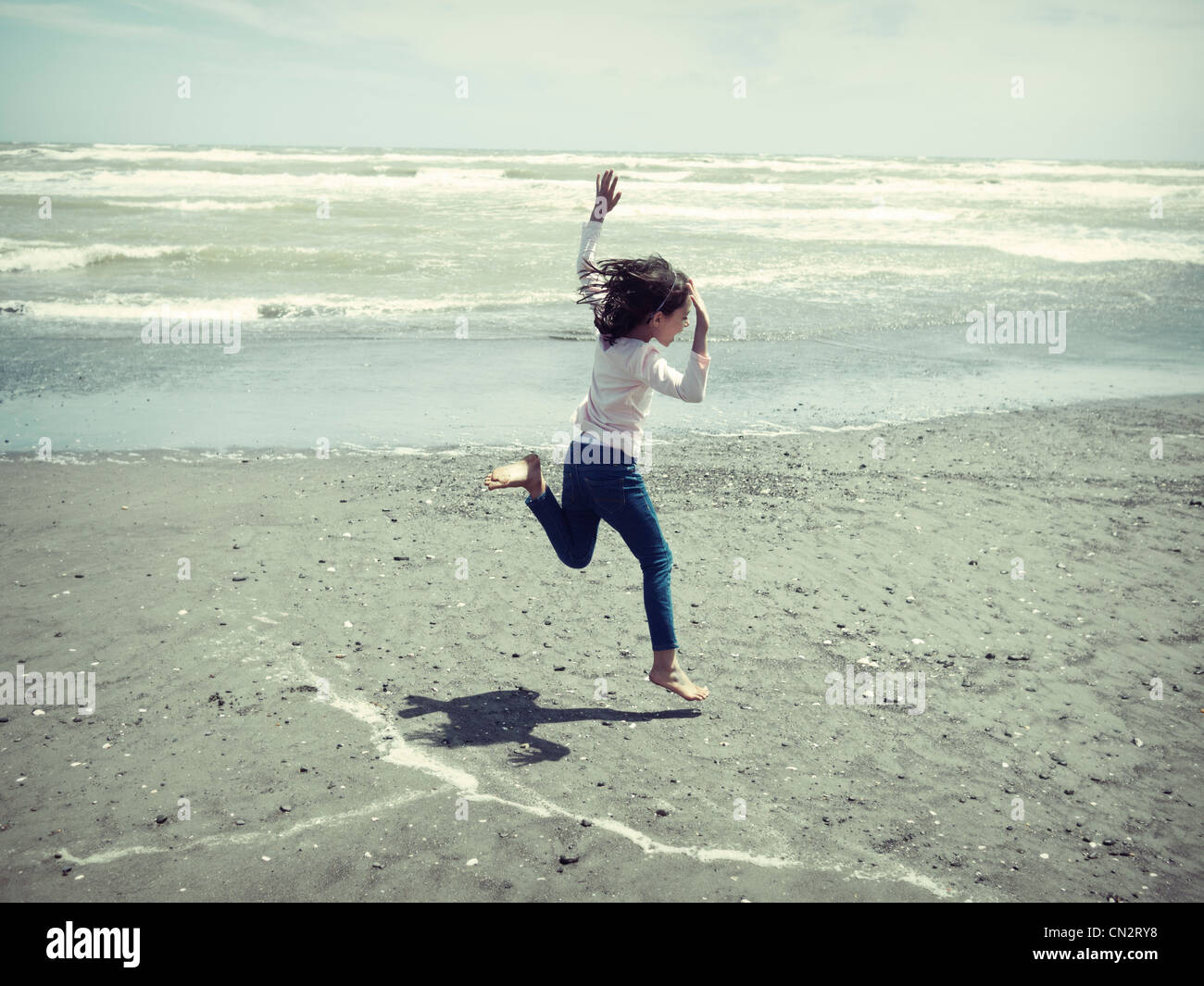 Mädchen springt am Strand. Stockfoto
