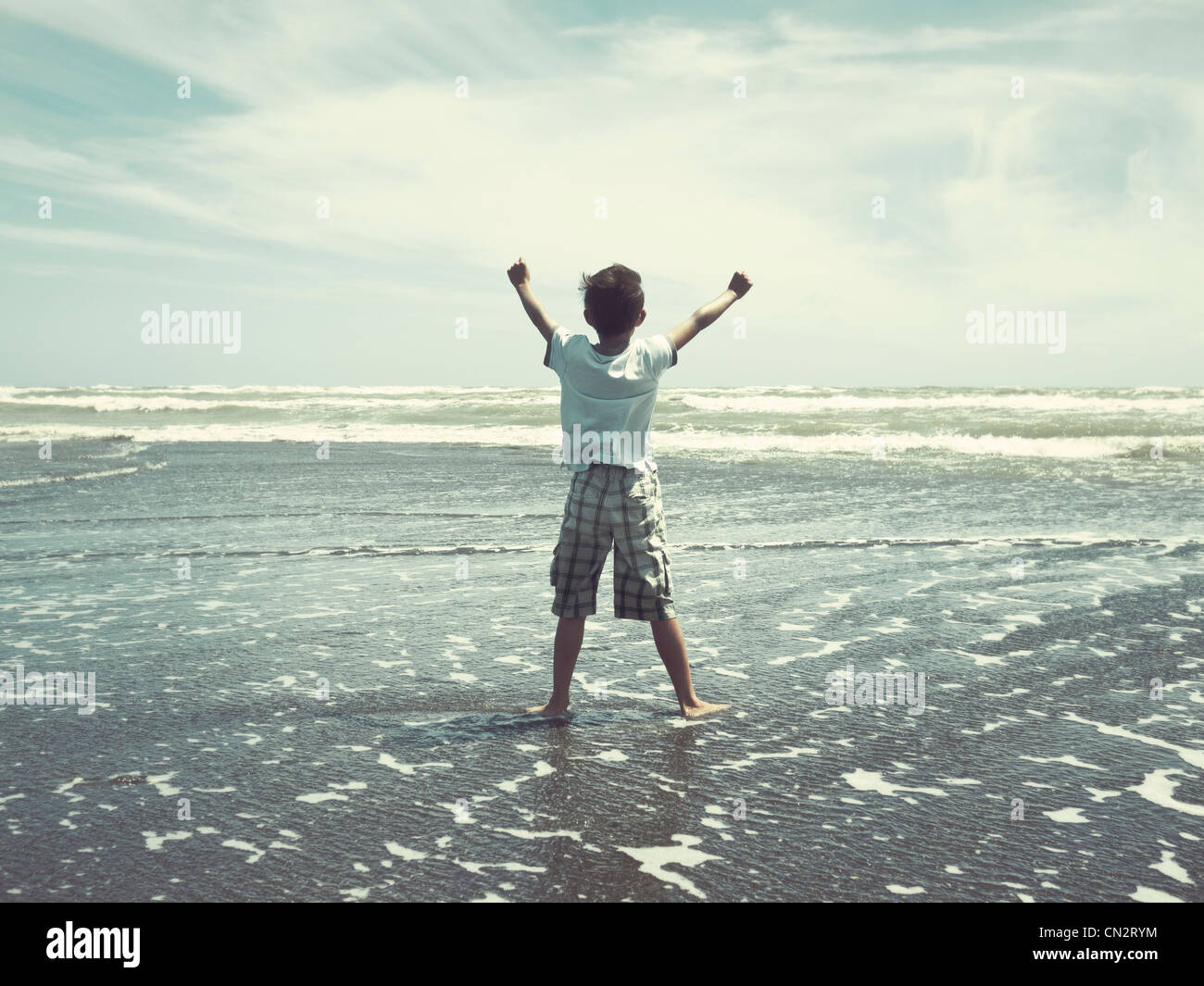 Ich halte zurück zum Meer: Boy am Strand, New Zealand. Stockfoto