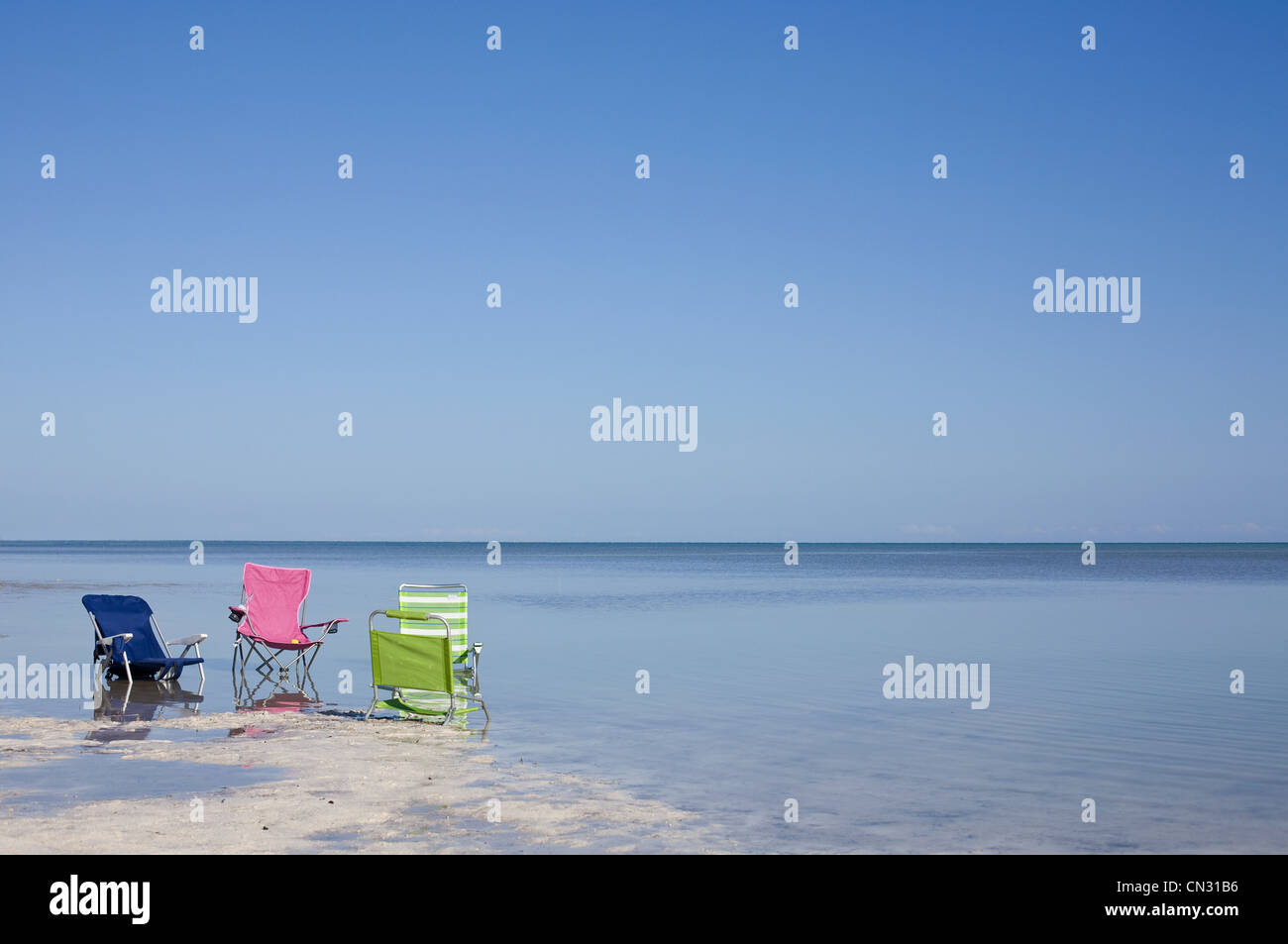 Drei Liegestühle am Strand Stockfoto