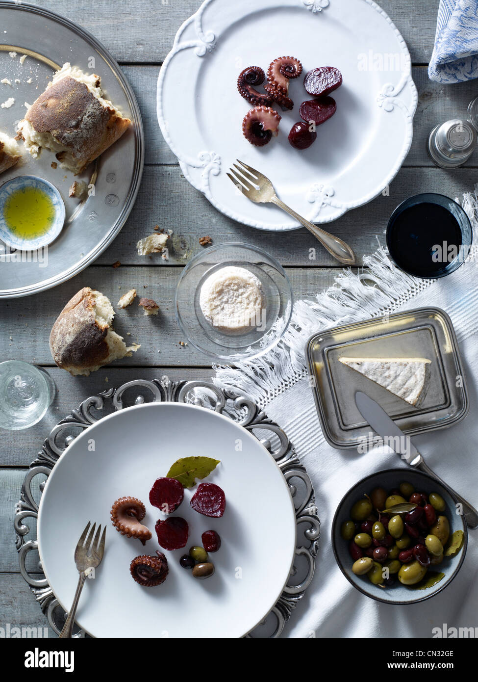 Tisch mit Platten von frischem Brot, Tintenfisch, Oliven und rote Beete Stockfoto